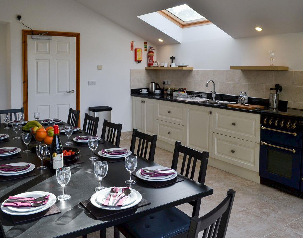 The dining room and kitchen at Buckland Barn in Buckland Brewer